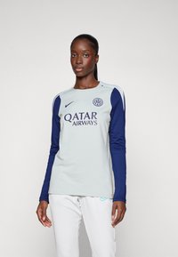 Maillot de sport à manches longues gris clair avec des accents bleu marine, présentant un col rond et des logos de Nike et Qatar Airways.