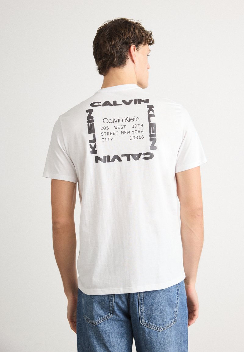 Tricou alb din bumbac, cu un print grafic negru pe spate, având detalii ale brandului aranjate într-un model pătrat. Croială casual.