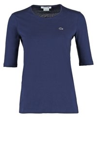 T-shirt Lacoste bleu marine à manches courtes et col rond avec petit logo crocodile brodé sur le côté gauche de la poitrine.