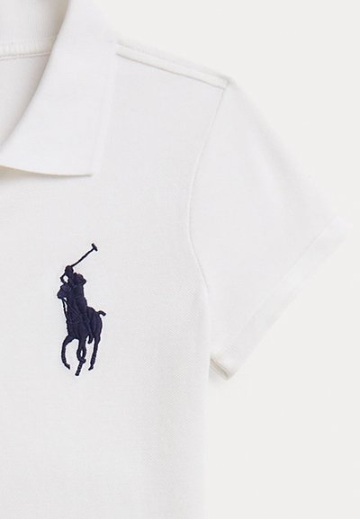 Λευκό πόλο μπλουζάκι από βαμβάκι, με υφασμάτινη υφή, κοντά μανίκια και κέντημα με λογότυπο παίκτη πόλο σε ναυτικό μπλε χρώμα στο αριστερό στήθος.