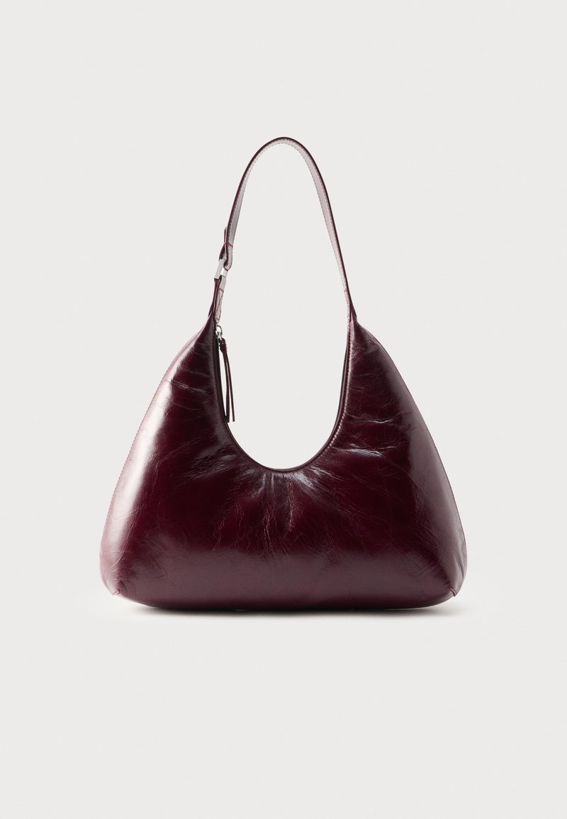 Sac à bandoulière en cuir bordeaux foncé avec une finition lisse et brillante, équipé d'une seule sangle avec un détail boucle en argent.