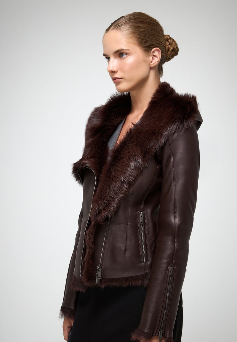 Bordeaux læderjakke med en faux fur krave. Har lynlåslommer og en skræddersyet pasform, med en glat tekstur og elegant design.