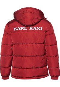 Czerwona kurtka puchowa z kapturem, z poziomymi przeszyciami, elastycznymi mankietami oraz wyszywanym na plecach napisem "KARL KANI" w kolorze białym.