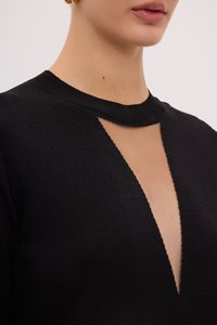 Schwarzer Pullover mit hohem Ausschnitt, der einen tiefen Ausschnitt an der Brust zeigt. Der Stoff wirkt weich mit einer subtilen Textur.