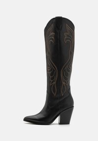 Bota de cowboy de cuero negro con costuras decorativas en marrón, punta afilada y tacón apilado en ángulo.