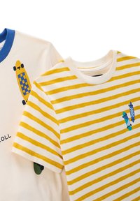 Deux t-shirts : l'un avec un col bleu et un graphique de skateboard, l'autre avec des rayures jaunes et blanches et des skateboards sur la poitrine.