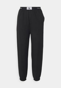 Pantalons de jogging noirs en tissu doux, dotés d'une taille élastique avec le logo Calvin Klein et des poignets fuselés aux chevilles.