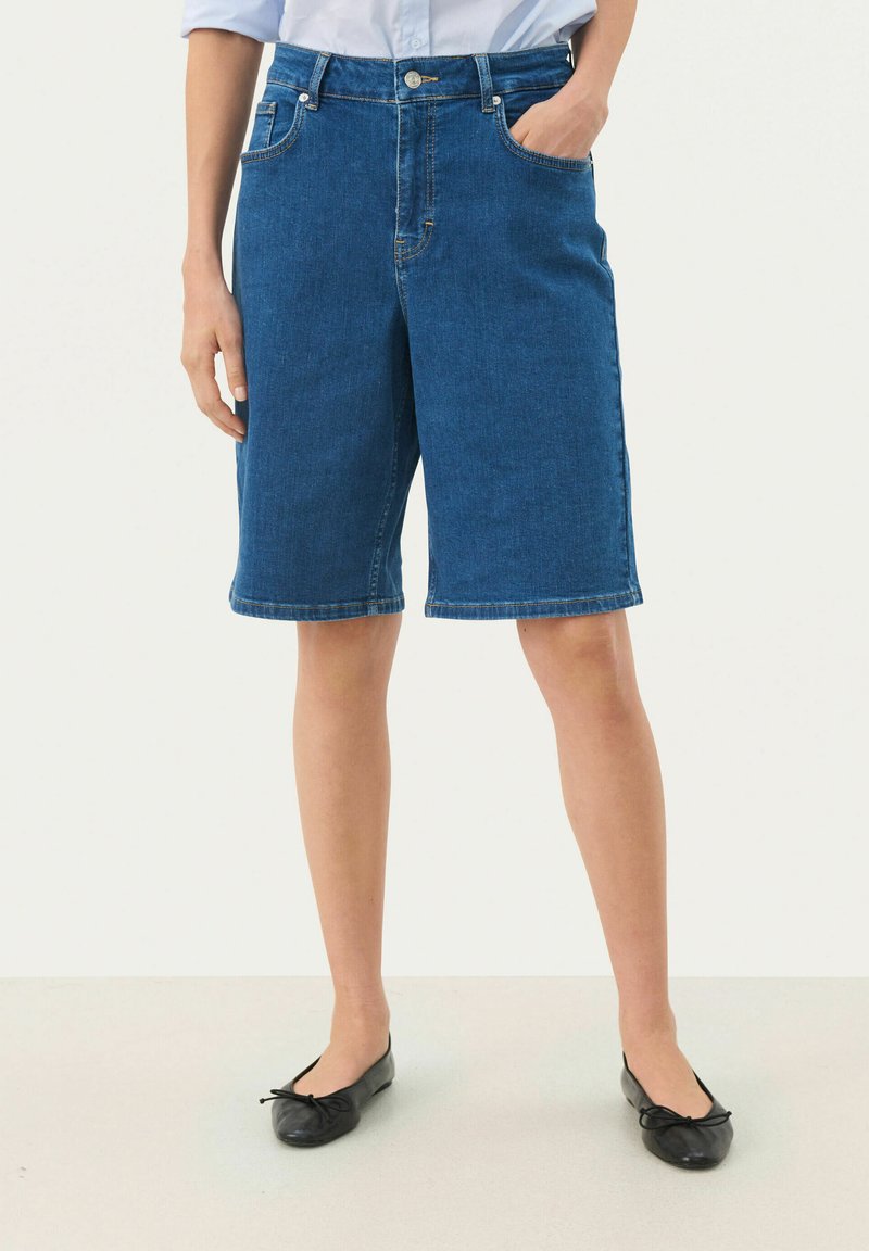 Denim bermudu šorti vidēji zila krāsā, ar augstu jostasvietu, priekšējām kabatām un taisnu griezumu, ar salocītiem apakšmalēm, lai nodrošinātu glītu apdari.