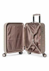 Valise rigide beige avec intérieur ouvert, présentant une doublure en tissu lisse, des sangles croisées et une serrure intégrée sur le côté.