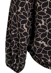 Mustassa kankaassa oleva paita, jossa on vaaleanbeige kukkakuvio, pitkät keräillyt hihat ja pehmeä rakenne.