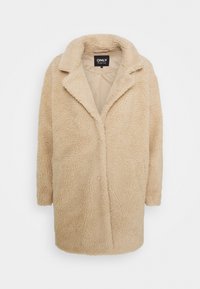 Beige faux bontjas met een reverskraag, lange mouwen en een open voorkant. Zachte, gestructureerde stof overal. Merketiket zichtbaar.