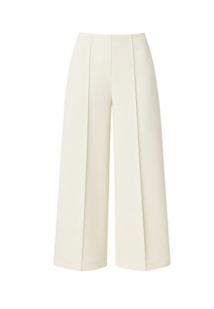 Kõrge vöökohaga laia lahendusega püksid valgelt toonilt kangast, millel on ees voldid ja lühendatud pikkus.