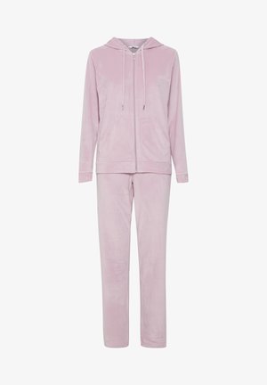 Růžový velurový teplákový set se zipovou mikinou a odpovídajícími kalhotami. Tkanina má měkkou texturu a mikina má přední kapsy.