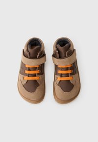 Brown and tan toddler shoes with orange elastic laces and a tan velcro strap on a white background.