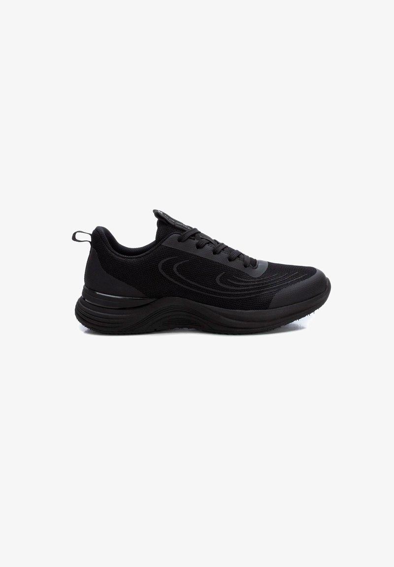 Zapatos deportivos negros con parte superior de malla, punta redondeada, suela gruesa y acolchada, y acentos sutiles. Cuenta con un sistema de cierre con cordones y una pestaña para tirar.