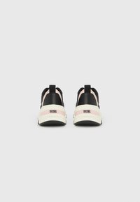 Μαύρα και ροζ αθλητικά παπούτσια Diesel, που φαίνονται από πίσω, με λευκές μεσαίες σόλες και μαύρες λωρίδες για κράτημα.