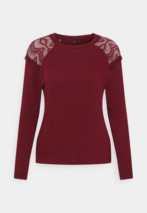 Long-sleeve burgundy top with lace detailing on shoulders and round neckline, made of soft, smooth fabric.