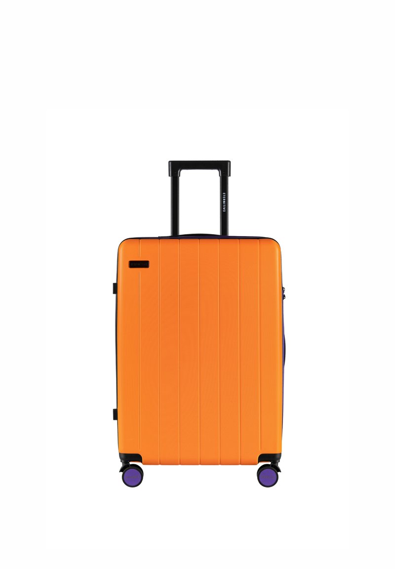 Hartschalenkoffer in leuchtendem Orange mit vertikalen Rillen, schwarzem Teleskopgriff und vier violetten Rollen für Mobilität.