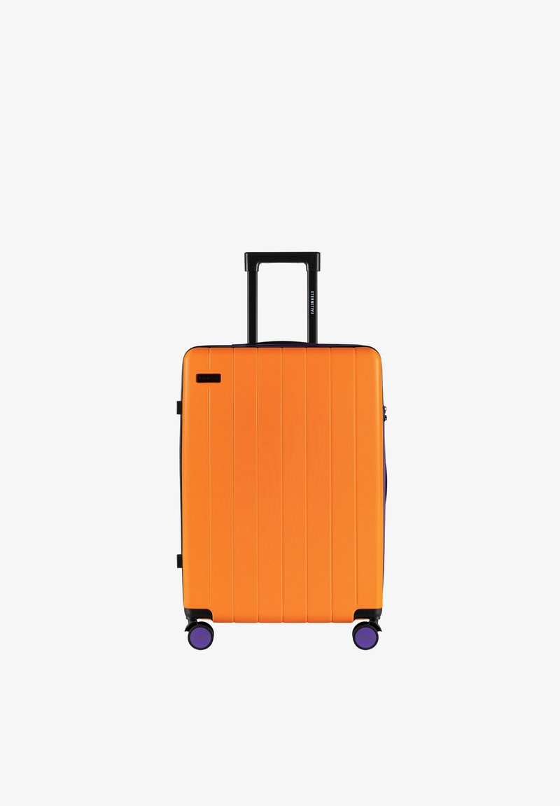 Hartschalenkoffer in leuchtendem Orange mit vertikalen Rillen, schwarzem Teleskopgriff und vier violetten Rollen für Mobilität.