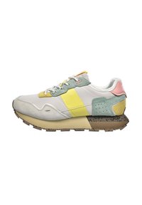 Sneaker z mieszanką materiałów; ma szary podstawowy kolor, żółte i zielone akcenty, jasnoróżowy zapiętek orazteksturowaną brązową podeszwę z drobnymi plamkami.