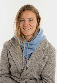Lichtblauwe gebreide hoodie met trekkoorden en houten accenten, gedragen over een gestructureerde grijze jas met een notch-kraag.