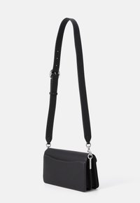 Borsa a tracolla in pelle nera con una texture liscia, forma rettangolare elegante, accessori in argento e dettagli di cucitura a contrasto lungo il bordo.