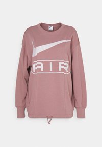 Růžová oversized mikina s bílým logem Nike a potiskem "AIR". Má dlouhé rukávy a šňůrku na spodním lemu. Měkká textilie.