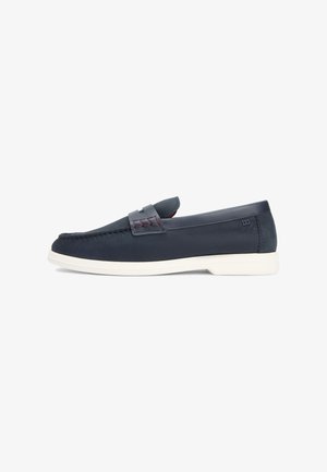 Heren loafers in marineblauw leer met witte zool, mocassinnaaien en klein logo vlakbij de hiel, op een witte achtergrond.