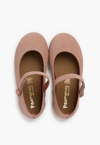 Zapatos Mary Jane de cuero rosa con puntera redondeada, correa al tobillo con botón y textura suave. Marca dorada visible en la plantilla.