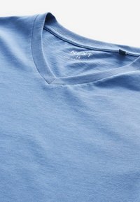 Modrá bavlněná tričko s výstřihem do V. Hladká textura, krátké rukávy a štítek na výstřihu. Jednoduchá a klasická estetika.