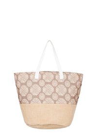 Canvas toteväska med ett ljusbrunt mönstrat lock som har blomsterdesign och en texturerad beige botten. Vita tyghandtag för enkel bärning.