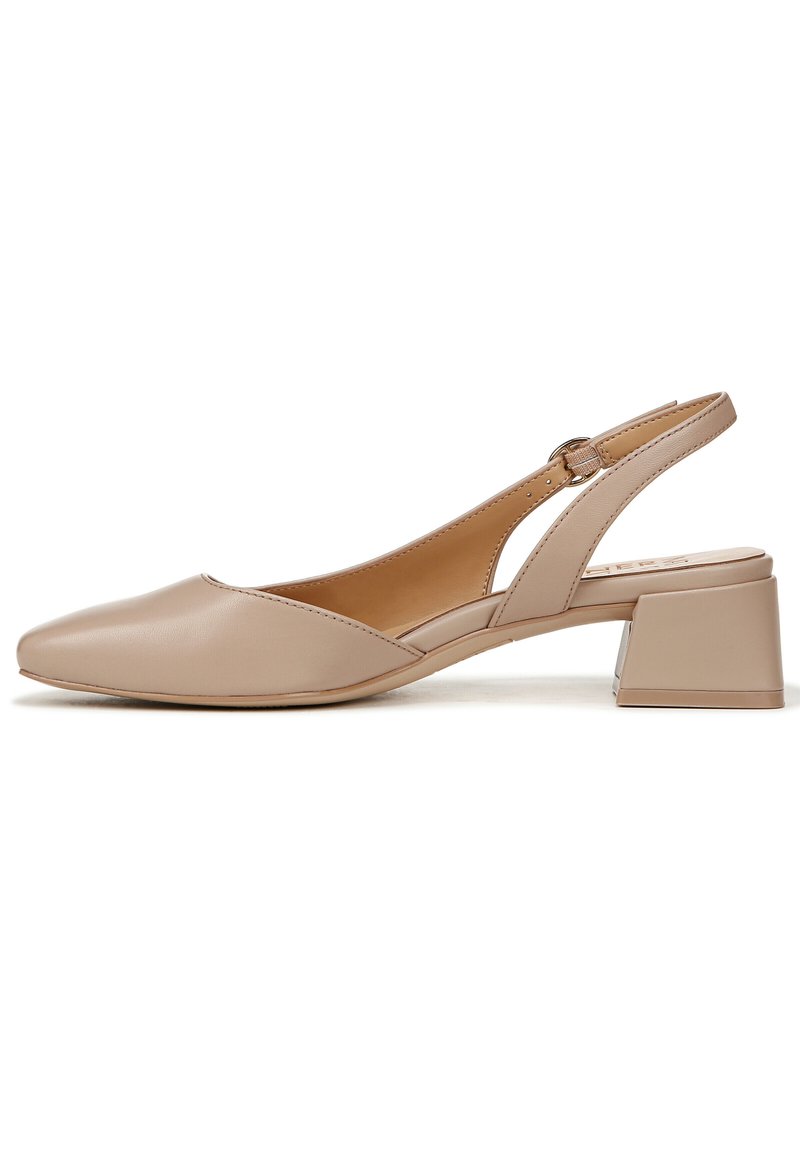 Beige leren slingback pump met een spitse neus, een lage blokhak en een gespsluiting aan de zijkant. Gladde textuur.
