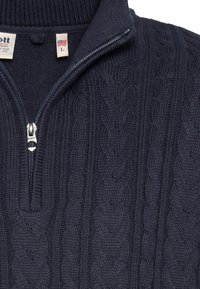 Granatowy dziany sweter z kołnierzem na zamek błyskawiczny, z wzorem splotu warkocza i prążkowanymi detalami. Metka wskazuje rozmiar L.