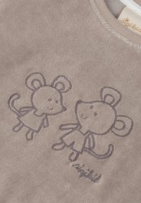 Brauner Stoff mit strukturierter Oberfläche und zwei gestickten Mausmotiven. Die Mäuse haben runde Ohren, lächelnde Gesichter und einfache Kleidung.