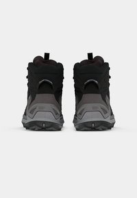 Botas de caminhada de cano alto em materiais sintéticos nas cores preto e cinza. Apresenta padrões texturizados, calcanhar reforçado e sola de borracha robusta com tração.