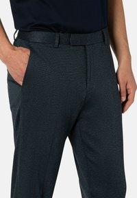 Mannen's donkerblauwe broek van een gestructureerde stof, met een tailleband met lussen, zijzakken en een recht gesneden pijp.