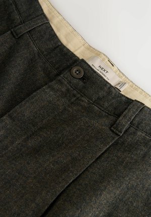 Tamsiai pilkos žakardo dirbtinės vilnos kelnės su juodu mygtuku ir smėlio spalvos vidiniu liemeniu, pažymėtu „Next Regular Tapered Fit“. 