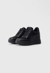 Sneaker a zeppa nere con un esterno in pelle liscia, pannelli in mesh, lacci frontali e dettaglio del logo sulla linguetta e sul tallone.