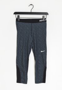 Musta ja sininen kuvioitu legginsit valkoisilla sydämen muodoilla, tyylikäs muotoilu ja Nike-logo alhaalla lahkeessa. Valmistettu joustavasta kankaasta.
