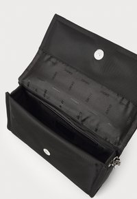 Black fabric wallet with a snap closure, featuring an interior lining with repeated logo pattern, multiple card slots, and a zipper pocket.