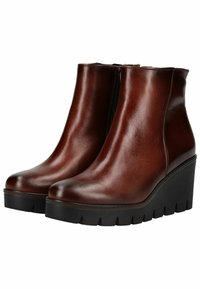 Bottines à talons compensés en cuir marron avec une finition brillante, un design épuré et une semelle plateforme noire texturée. Dispose d'une fermeture éclair sur le côté pour plus de facilité.