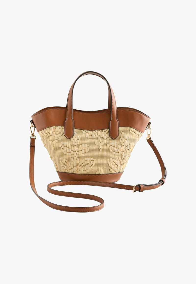 Sac à main tissé avec garniture en cuir marron, motif floral, double anses supérieures et bandoulière longue réglable sur fond blanc.