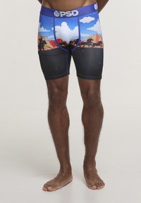 Męskie szorty kompresyjne z grafiką przedstawiającą niebieskie niebo i góry, z czarnym dolnym pasem oraz niebieskim paskiem w talii z logo.