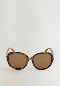 Lunettes de soleil écaille de tortue avec de grandes lentilles carrées et une teinte brune. Elles comportent des éléments en métal doré sur les branches. Monture en polycarbonate.