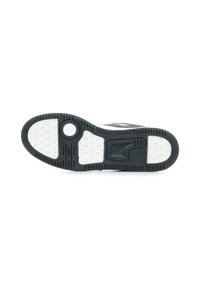 Semelle de chaussure de sport noire et blanche avec un motif en caoutchouc texturé, des éléments de design circulaires, et des rainures pour la traction le long des bords.