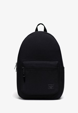 Sac à dos en tissu noir avec une forme arrondie, poche avant zippée et une poignée supérieure. Possède une étiquette de logo sur le panneau avant inférieur.