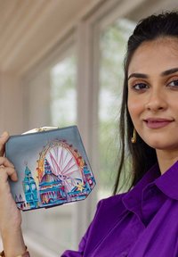 Hexagonale leren clutch met een kleurrijke afdruk van de skyline van Londen, inclusief iconische bezienswaardigheden en een gouden sluiting.