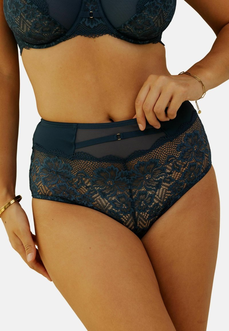 Culotte en dentelle taille haute de couleur bleu sarcelle avec des motifs floraux, des panneaux en mesh et des accents en satin. Présente une taille lisse avec un clip décoratif.