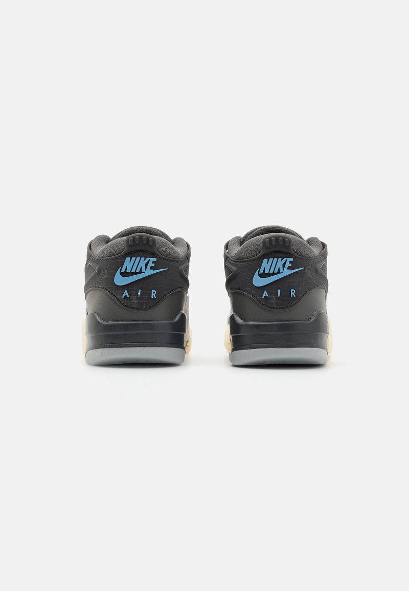 Baskets Nike Air avec une tige noire, un logo bleu, un col rembourré, des détails texturés, et une semelle intermédiaire crème et une semelle extérieure grise.