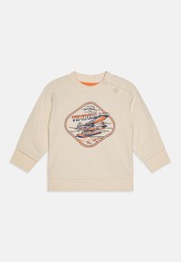 Krämfärgad sweatshirt med rund halsringning, med ett grafiskt tryck av ett flygplan och "TIMBERLAND." Inkluderar knappdetaljer på axeln.